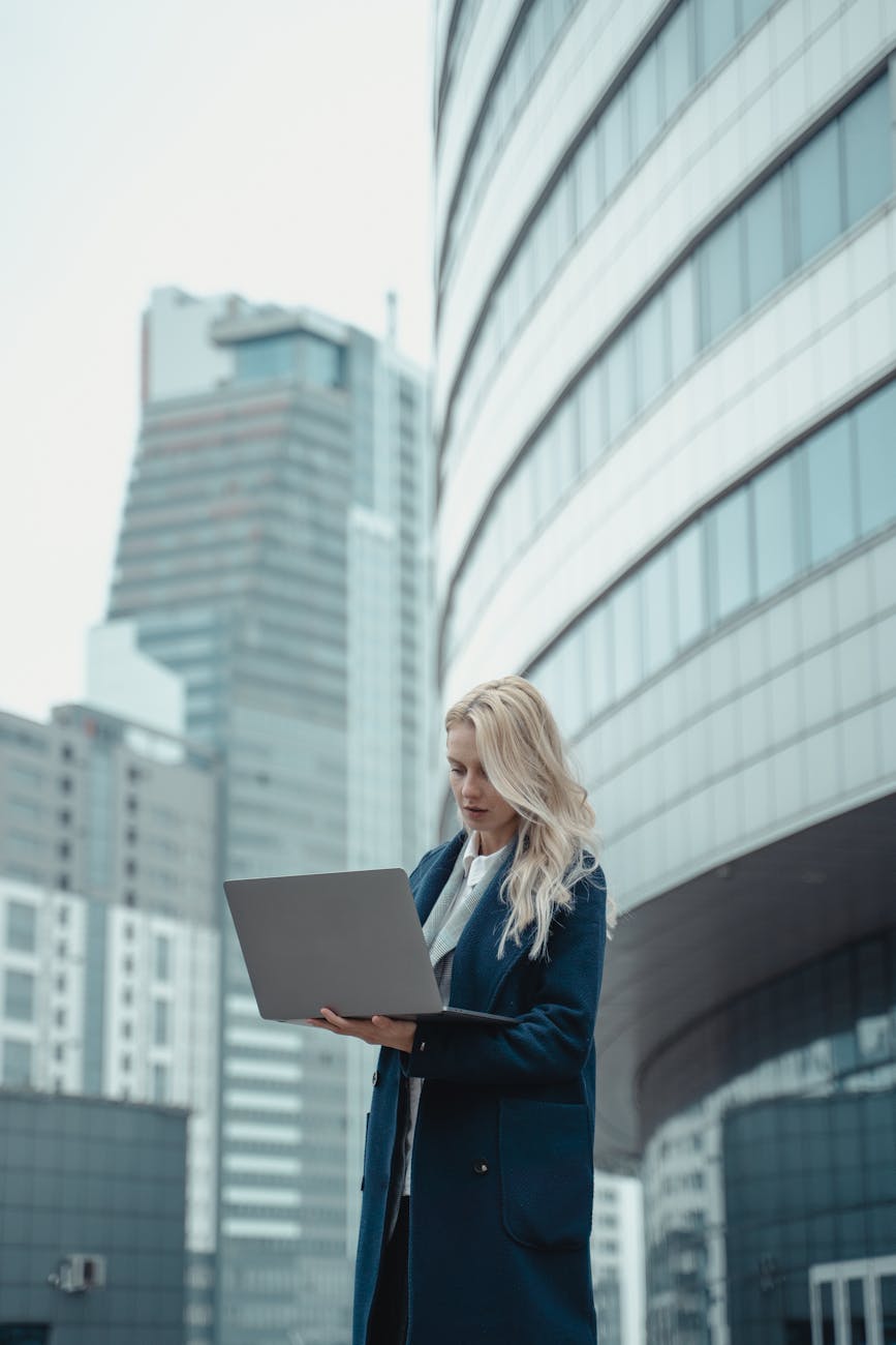 a woman in a blue coat using a laptop