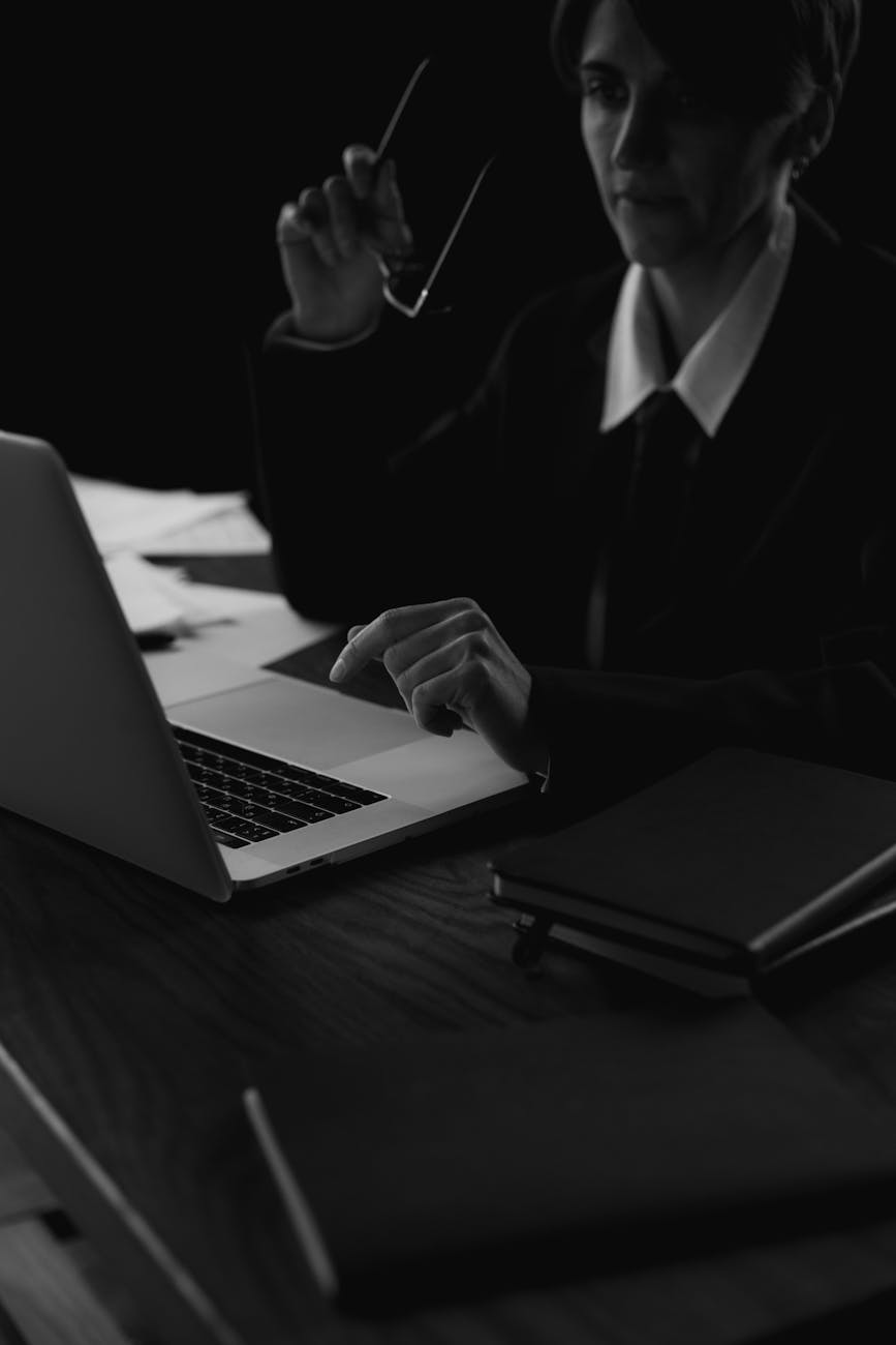 grayscale photo of a woman sitting at the table